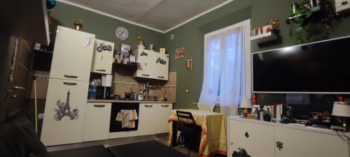 a kitchen with a refrigerator and a television in it at Batman secret in Pontedera