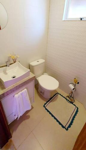 a bathroom with a white toilet and a sink at Casa temporada Grecco Vidal in Venda Nova do Imigrante