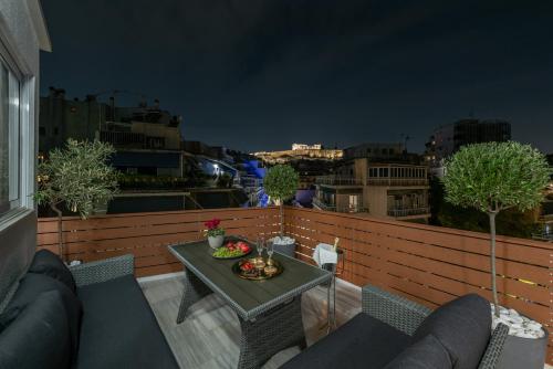 uma varanda com uma mesa com uma taça de fruta em Acropolis Divine Penthouse em Atenas