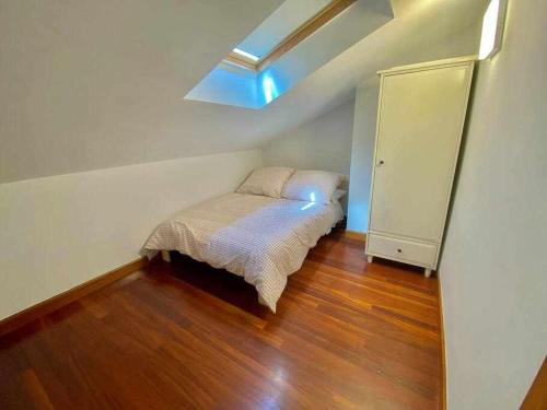 - une petite chambre avec un lit et une lucarne dans l'établissement Gure Etxetxue - Apartamento duplex muy soleado, à Bermeo