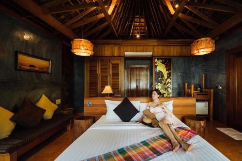 a woman laying on a bed in a room at Andalay Beach Resort Koh Libong in Ko Libong