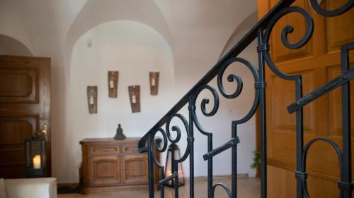 a staircase with a wrought iron railing and a wooden door at Heart of Klosterneuburg in Klosterneuburg