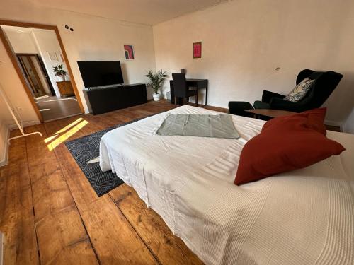 a bedroom with a white bed with red pillows at Heart of Klosterneuburg in Klosterneuburg