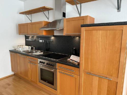 a kitchen with wooden cabinets and a stove top oven at Heart of Klosterneuburg in Klosterneuburg