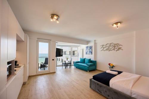 a bedroom with a bed and a blue couch in a room at Mara Sea View Apartment in Năvodari