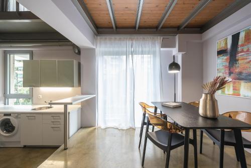 a kitchen and dining room with a table and chairs at Artsy Urban Loft in Athens in Athens
