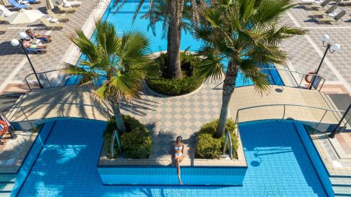 an overhead view of a swimming pool with palm trees at Hydramis Palace Beach Resort in Georgioupolis