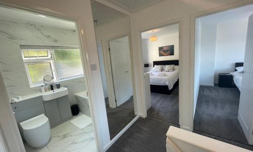 a bathroom with a sink and a toilet and a bed at Driftwood Villa - NEW LISTING in Brixham