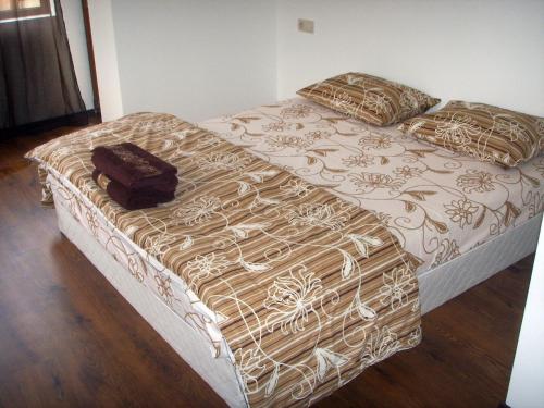- un lit avec une couverture et des oreillers marron et blanc dans l'établissement The Lake Villa, à Smolyan