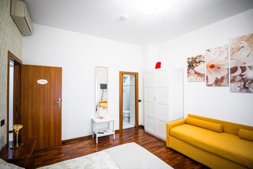 a living room with a yellow couch in a room at Brigida B&B in Monteprandone