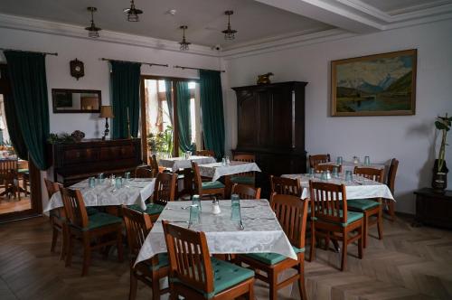 a dining room with tables and chairs with white tablecloths at Paleus Resort in Oradea