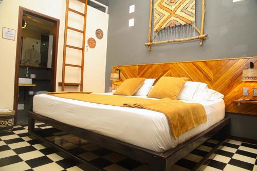 a bedroom with a large bed with a wooden headboard at Masaya Santa Marta in Santa Marta
