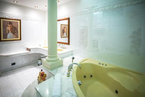 a white bathroom with a tub and a sink at Brigida B&B in Monteprandone