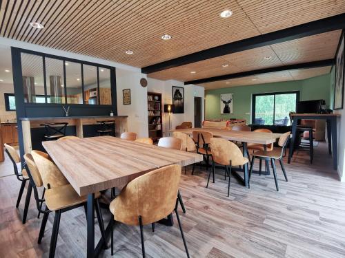 une salle à manger avec une grande table et des chaises en bois dans l'établissement Hostel des Combes, à Les Combes