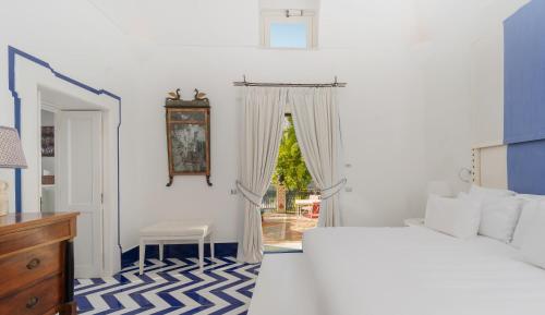 a white bedroom with a bed and a window at Villa Treville in Positano