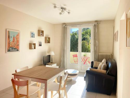 un salon avec une table et un canapé dans l'établissement Toussaint by Yumē, à Toulouse