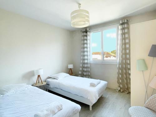 deux lits dans une chambre avec une fenêtre dans l'établissement Toussaint by Yumē, à Toulouse
