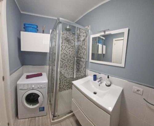 a bathroom with a shower and a sink and a washing machine at Eldorado VIVIAN-STUDIO FREE WIFI in Playa de las Americas