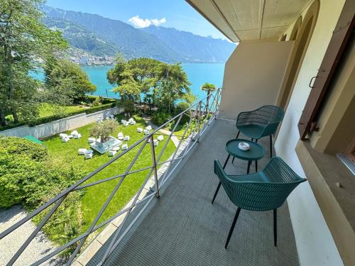 a balcony with two chairs and a view of the water at La Villa in Montreux
