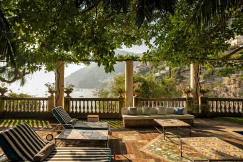 a patio with two chairs and a couch and a table at Villa Treville in Positano