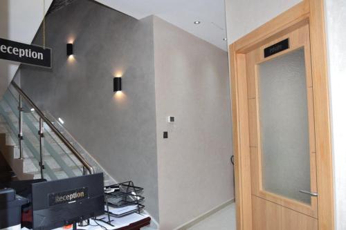 un couloir avec un escalier doté d'une porte et d'un escalier. I Hbestosbestos dans l'établissement Ghazalle oasis Hotel GB, à El Biar