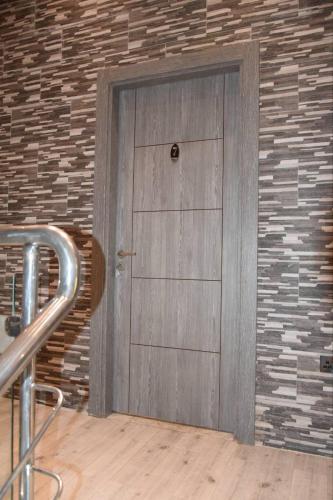 a wooden door in a brick wall at Ghazalle oasis Hotel GB in El Biar