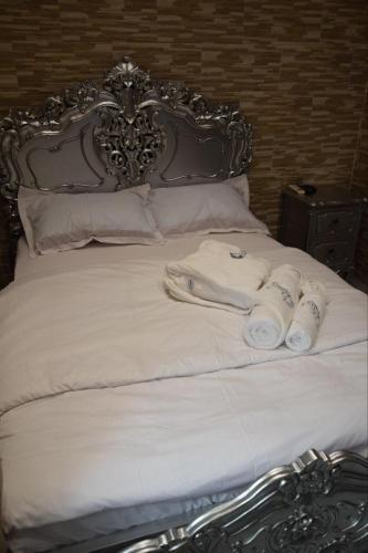 a bed with white sheets and rolled towels on it at Ghazalle oasis Hotel GB in El Biar