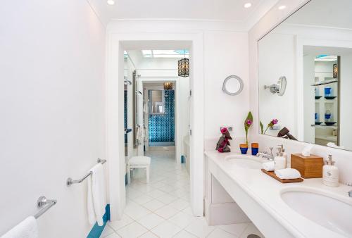 a white bathroom with a sink and a mirror at Villa Treville in Positano
