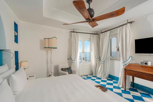 a bedroom with a bed and a ceiling fan at Villa Treville in Positano