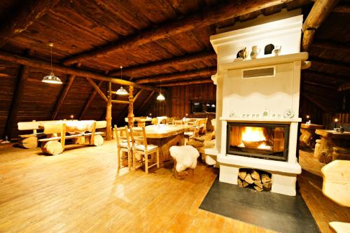 a living room with a fireplace and a dining area at Hotel Zochova Chata - Adult friendly in Modra