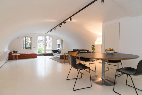 a dining room and living room with a table and chairs at Wellness Apartment on the Wharf Utrecht in Utrecht