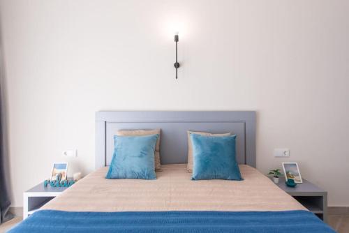 - une chambre avec un grand lit et des oreillers bleus dans l'établissement GG Home - new, cozy 1-bedroom apartment in Domus, à Tbilissi