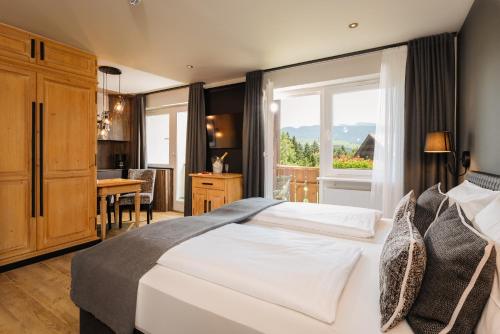 a bedroom with a large white bed and a table at MONDI Resort und Chalet Oberstaufen in Oberstaufen