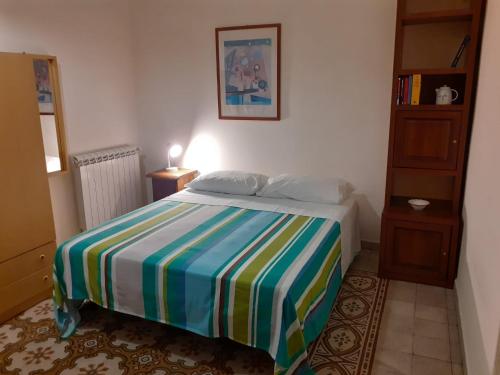a bedroom with a bed with a colorful striped blanket at Casa nonno Enrico in via Oreto in Palermo