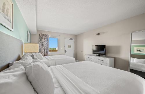 a hotel room with two beds and a television at Camelot By The Sea 1206 in Myrtle Beach