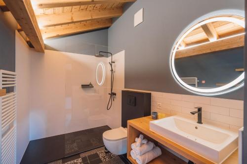 ein Bad mit einem Waschbecken und einem Spiegel in der Unterkunft Hotel Walliserkanne in Grächen