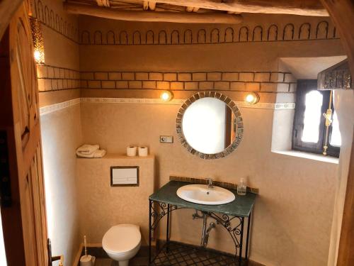a bathroom with a sink and a mirror at Kasbah Hotel Ait Omar in Nkob