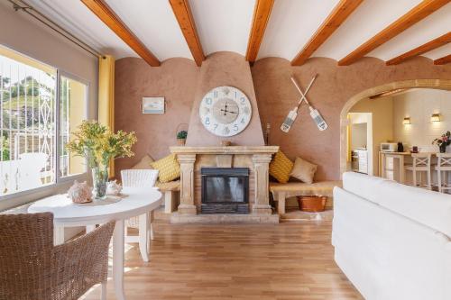 a living room with a fireplace and a clock on the wall at Villa Gota de Mar in Jávea