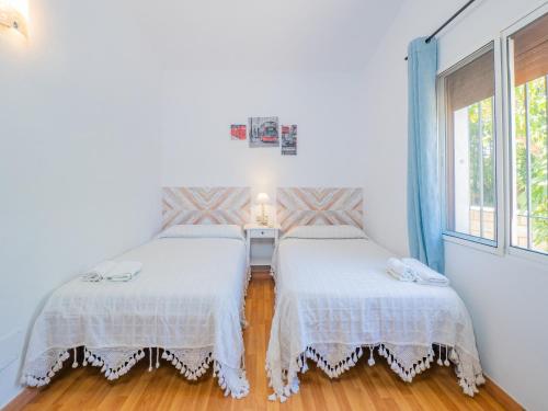 a bedroom with two beds and a window at Cubo's Finca Vallehermoso in Alhaurín el Grande