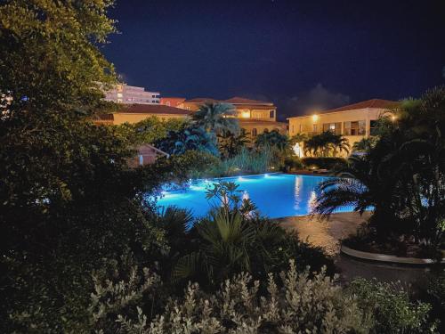 a swimming pool in a yard at night at Superb 3-Bed Designer Apartment in Cupecoy