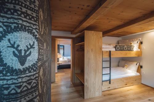 a bedroom with bunk beds and a wall with a mural at Hotel Walliserkanne in Grächen