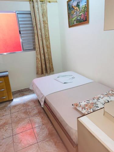 a small bedroom with a bed and a window at Hotel Mooca in Sao Paulo