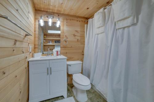 La salle de bains est pourvue de toilettes blanches et d'un lavabo. dans l'établissement Kodak Getaway with Covered Decks and Game Room!, à Kodak