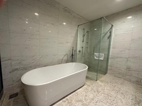 y baño con bañera blanca y ducha acristalada. en The Platinum KLCC by Moonlight en Kuala Lumpur