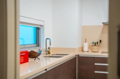a kitchen with a sink and a window at Suite CU - Sea View - 3 Pools - AC - Free Park - Free Gym in Funchal
