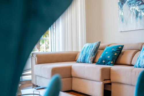 a living room with a couch with blue pillows at Suite CU - Sea View - 3 Pools - AC - Free Park - Free Gym in Funchal
