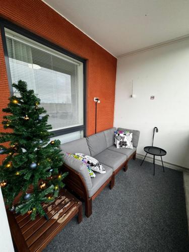 a living room with a christmas tree and a couch at Top floor flat with sauna, A/C & free parking in Vantaa