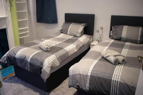 dwa łóżka siedzące obok siebie w sypialni w obiekcie Dolce Central Lord St. Flat 1 w mieście Southport