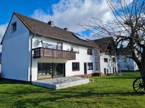 a large white house with a large yard at Ferienwohnung Dörnbergblick Klinge in Calden