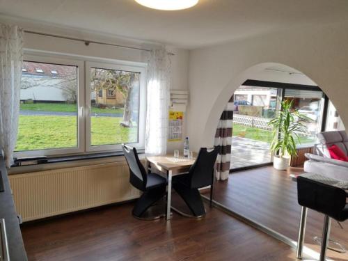 a dining room with a table and chairs and a window at Ferienwohnung Dörnbergblick Klinge in Calden